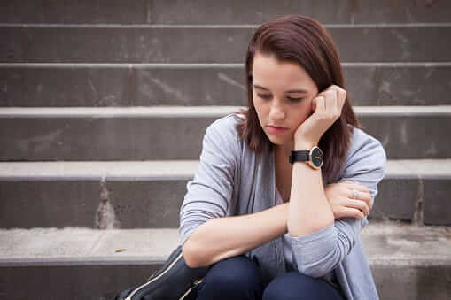 Woman sitting on steps contemplating that drug and alcohol dependence is no way to live 