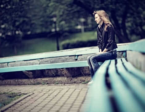 Woman sitting on bleachers looking lonely waiting to enter drug and alcohol treatment.