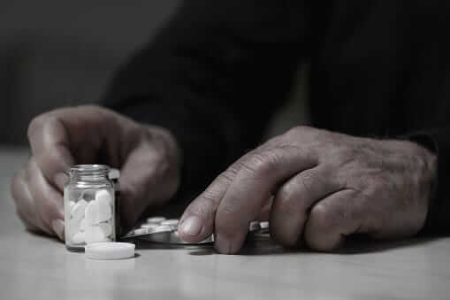 Pair of hands taking pills. Oxycodone addiction?