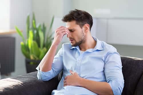 A man experiences uncomfortable withdrawal symptoms while wondering what is dilaudid addiction