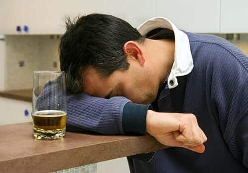 man potentially suffering from alcohol poisoning symptoms