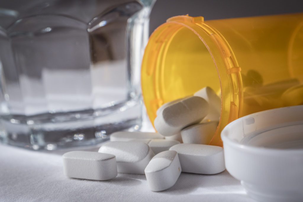 image of a pill bottle tipped over with prescription pills