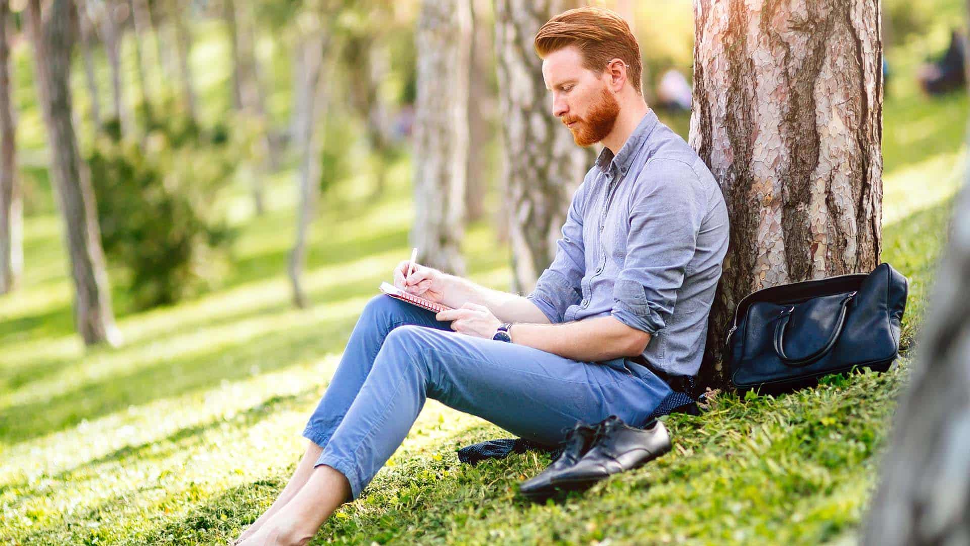 Handsome college student studying in park