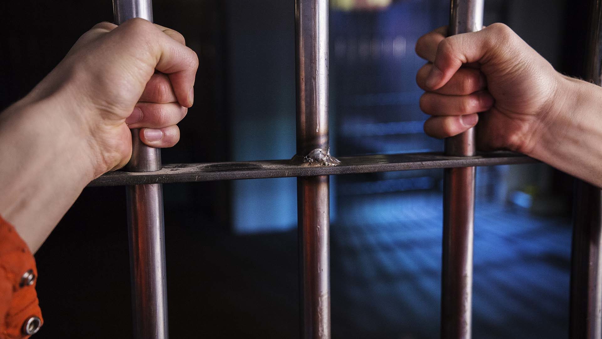 a man being held captive behind bars