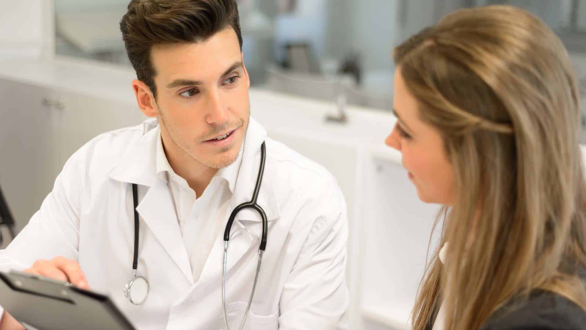 Portrait of a doctor listening to patient explaining her painful in his office