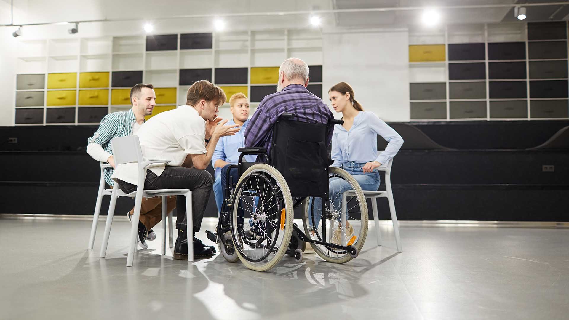 Back view portrait of handicapped man sharing troubles with support group during therapy session, copy space