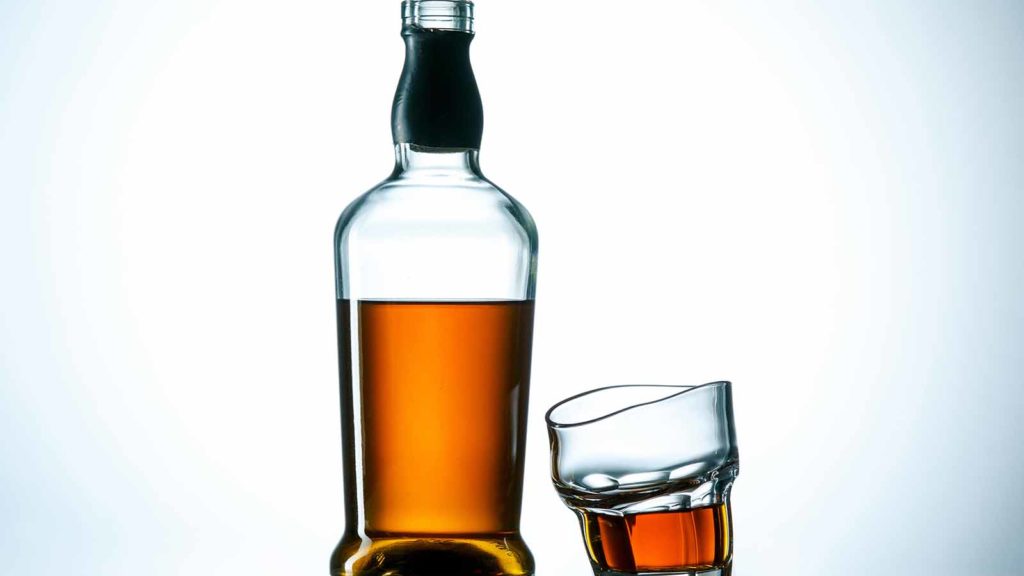 bottle-of-alcohol-and-tilted-cup