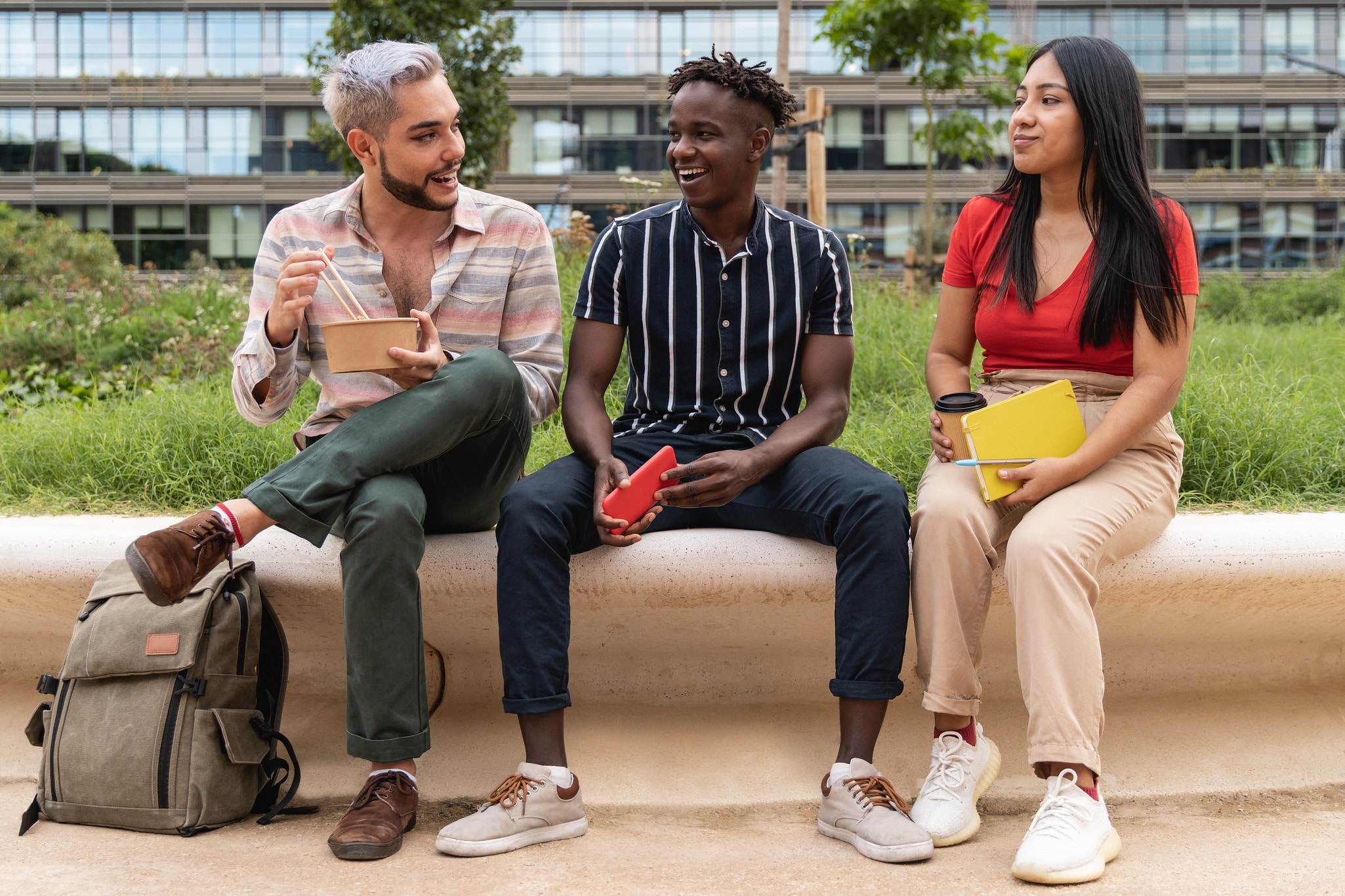 three friends sitting together outside a college class