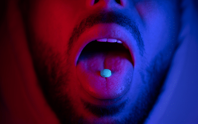 Ecstasy Addiction - Man with pill on tongue